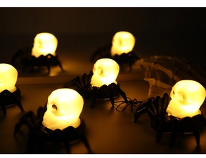 Close-up of LED Halloween spider skull candles with warm orange glow for party decor