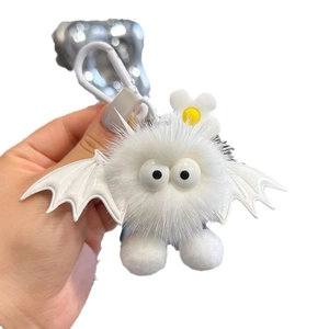 Cute white plush bat keychain with fuzzy wings and flower detail on silver backpack