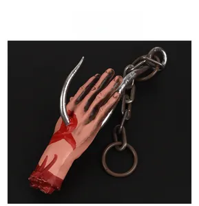 Detailed view of bloody severed hand hanging from a silver hook and plastic chain decoration