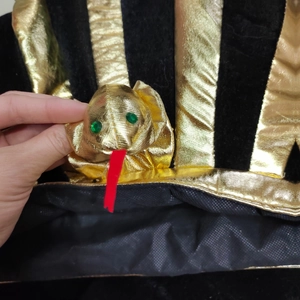 Detail of golden pharaoh hat with cobra head decoration and green crystal eyes