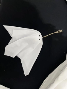 Ghost hanging decoration for Halloween party made of white fabric with rustic twine handle
