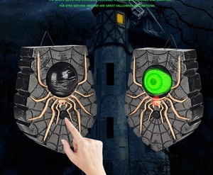 Detail of Halloween spider doorbell with glowing green eye and spooky sound effects