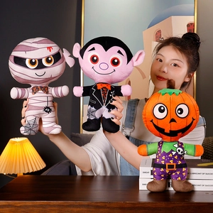 Trois peluches d'Halloween représentant une momie, un vampire et une citrouille tenus à la main