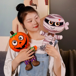 Peluches d'Halloween avec poupée citrouille et momie tenues par une personne