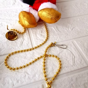 Père Noël électrique avec jambes en velours rouge, bottes dorées et chaîne de billes d'or