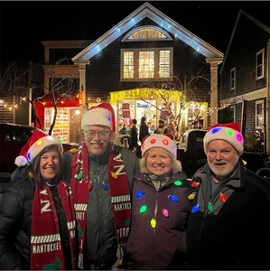 Outdoor night scene featuring group wearing LED Christmas hats and glowing bulb necklaces
