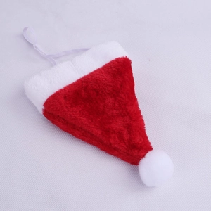 Dettaglio di un mini cappello natalizio di peluche rosso per animali con pon pon bianco