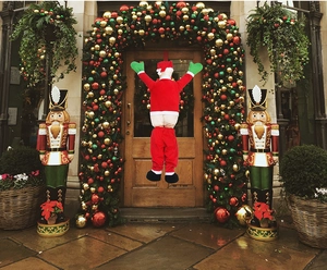 Funny climbing Santa decoration with pants down design on a festive Christmas porch