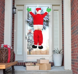 Funny Santa Claus stuck in door hanging decoration with red pants and green gloves