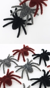 Macro detail of multi-color flocked spiders for Halloween decor in black, grey and red