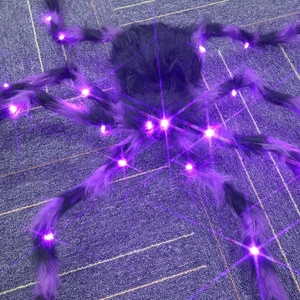 Close-up of a giant Halloween furry spider decoration with glowing purple LED lights
