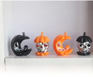 Detail view of Halloween pumpkin, moon and skull LED figurines set on a white shelf