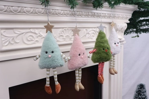 Detailed close-up of cute plush Christmas tree dolls hanging on a white festive fireplace