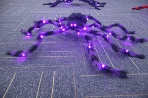 Detailed view of flexible giant spider legs featuring glowing purple LED light beads