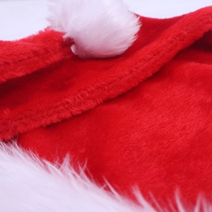 Close-up of thick plush texture and stitching on a long red Christmas hat with white fur trim