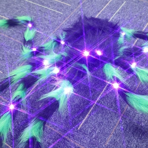 Macro detail of plush Halloween spider featuring glowing purple LED eyes and hairy legs