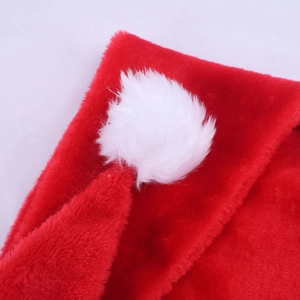 Vue détaillée du pompon blanc moelleux et du tissu en peluche rouge épais du bonnet de Noël