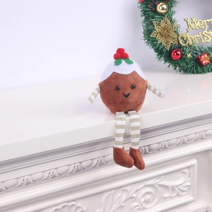 Detail of Christmas pudding plush doll with striped limbs on a festive white fireplace