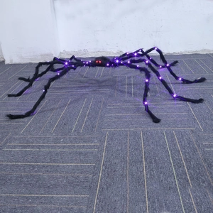 Detail of Halloween fuzzy black spider featuring purple LED legs and glowing red eyes