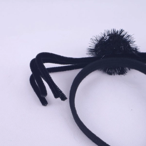 Detail of a black plush spider headband with fuzzy legs for Halloween party costume decor