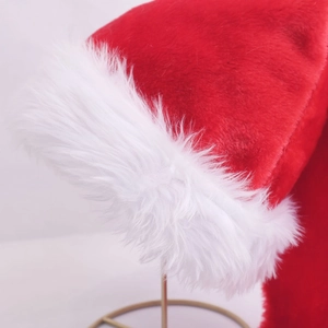 Detail of red plush fabric and fluffy white faux fur trim on a long Christmas hat