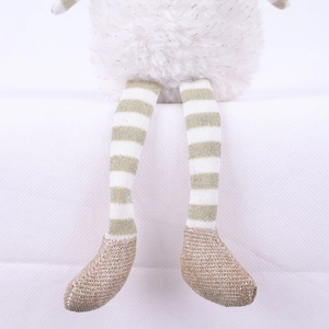 Close-up of plush Christmas doll legs with gold sequins and white faux fur detail
