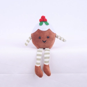 Macro detail of Christmas pudding plush doll with festive holly berries and striped legs