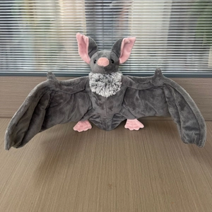 Détail d'une peluche de chauve-souris grise avec oreilles roses et col en fourrure