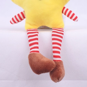 Close-up of plush star doll with red and white striped legs sitting on a white surface