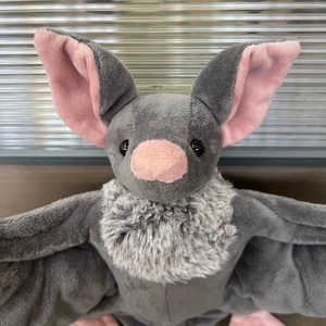 Détail de la peluche chauve-souris grise avec oreilles roses et col en fourrure douce
