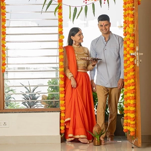 Indian wedding marigold garland with couple in traditional orange and blue festive attire