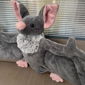 Gros plan d'une peluche de chauve-souris d'Halloween en fourrure grise et détails roses