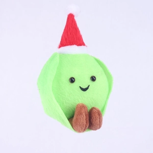 Close-up of green plush Christmas ornament with red hat and soft fabric texture