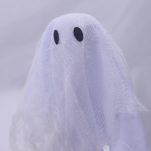 Close-up of Halloween ghost decor featuring white mesh fabric and black circle eyes