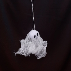 Close-up of white mesh Halloween ghost hanging decoration with black eyes and twine