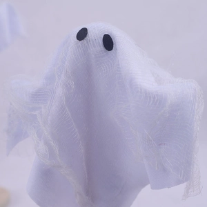 Detail of cute Halloween ghost ornament with layered white tulle and black oval eyes