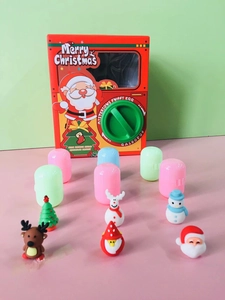 Detail of Christmas gashapon machine with Santa Claus design and colorful toy capsules