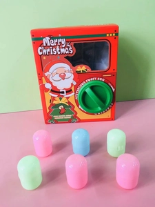 Detail of red Santa Gashapon machine with transparent window and colorful prize capsules