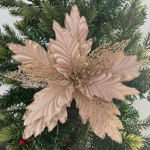 Close-up of champagne gold mesh Christmas flower with glitter on a green pine tree branch