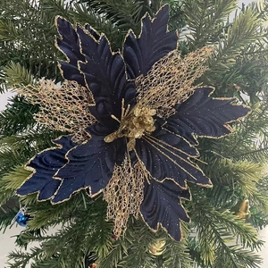Detail of navy blue Christmas mesh flower with gold glitter edges on pine background