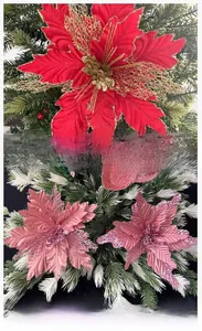Detail of red and pink mesh Christmas flowers with glitter coating on tree branches