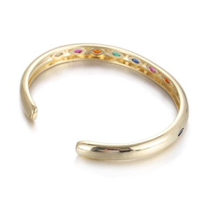Detailed view of a gold open bangle featuring vibrant rainbow-colored zircon stone inlays