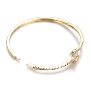 Detailed close-up of a golden cuff bracelet with colorful zircons and floral crystal motifs