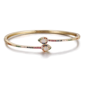 Detail of adjustable gold bangle featuring colorful cubic zirconia and teardrop motif
