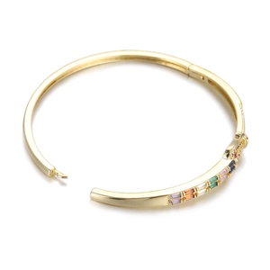 Detailed close-up of rainbow cubic zirconia inlay and gold clasp on minimalist bangle