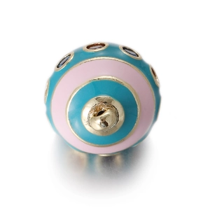 Detailed close-up of a colorful enamel jewelry charm with green and pink circular design