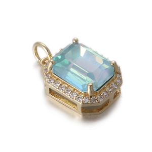 Detalle de un colgante de circón azul rectangular con piedras claras y una base dorada