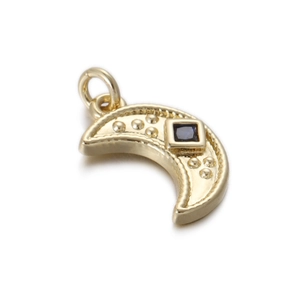 Detail of crescent moon gold pendant with blue gemstone and relief dot patterns