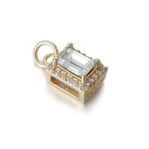 Detalle macro del colgante rectangular dorado con circón grande y engaste de pavé