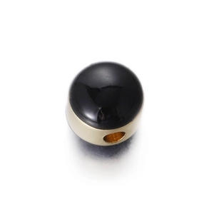 Macro detail of half-sphere bead with black polished dome and gold metal base with side hole